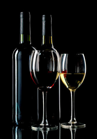 Red and white wine in bottles and wineglasses on black backgroundの写真素材