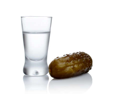 Studio shot of glass of vodka with pickled cucumber isolated on white backgroundの写真素材