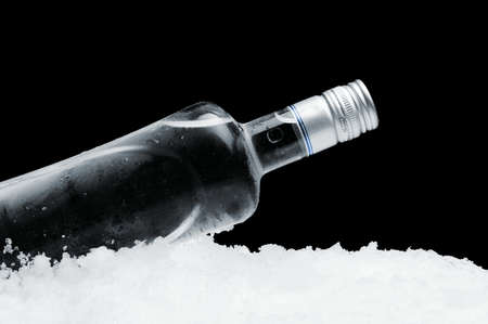 Close-up view of bottle of vodka lying on ice on blackの写真素材
