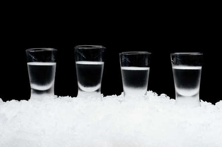 Close-up view of glasses of vodka on ice on black backgroundの写真素材