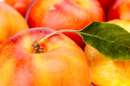 Background made from many orange and red colorful nectarines with leafの写真素材