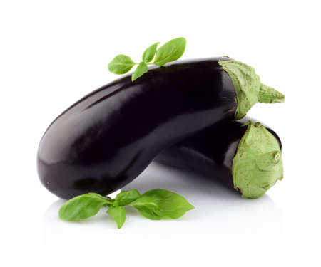 Close-up view of eggplants, aubergines fruit with basil leaves isolated on white backgroundの写真素材