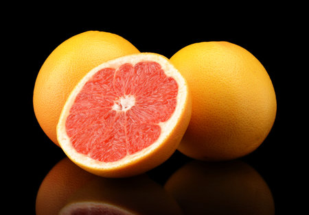 Studio shot of sliced three grapefruits isolated black background