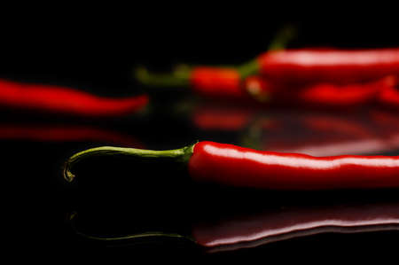 Studio shot of spicy chilli peppers on black backgroundの写真素材