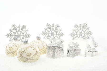 Decoration of silver christmas gifts,baubles,ribbon on snow withon whiteの写真素材