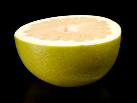 Half of pomelo, chinese grapefruit isolated on black backgroundの写真素材