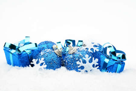 Decoration of blue christmas baubles and gifts on snow white backgroundの写真素材