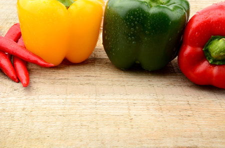 Closeup view various peppers on wooden kitchen table