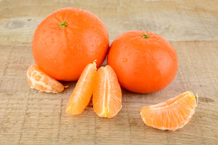Studio shot mandarines, tangerines on wooden table on white with piecesの写真素材
