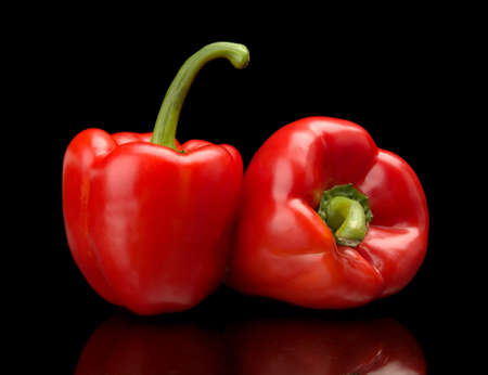 Studio shot of red bell peppers isolated on black backgroundの写真素材