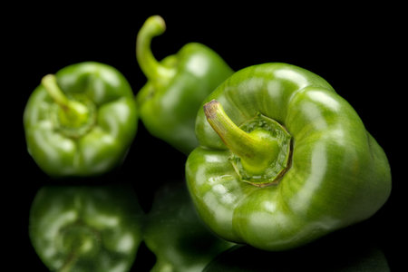 Studio shot macro view of green bell peppers in the corner isolated on black