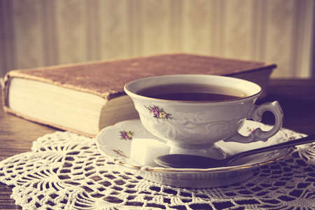 Cup of tea with poetry book on napkin in vintage effectの写真素材