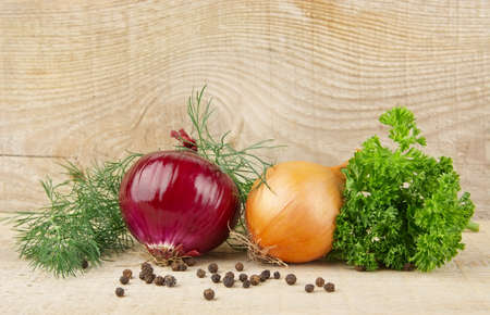 Onion,red onion,dill,parsley,allspice and black pepper on wooden backgroundの写真素材