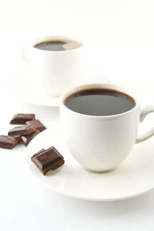 Coffee cups blocks of chocolate and saucer on white backgroundの写真素材