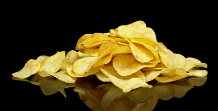Many potato chips on black background