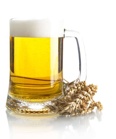 Pint of beer on table with ears of wheat isolated on white backgroundの写真素材