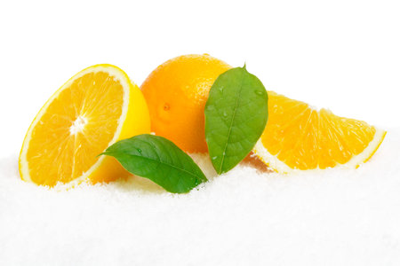 Orange fruits with ice cubes and orange fruit with citrus leaves on ice on white background
