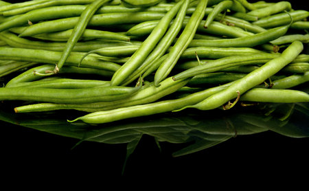 Stack of green beans on black background