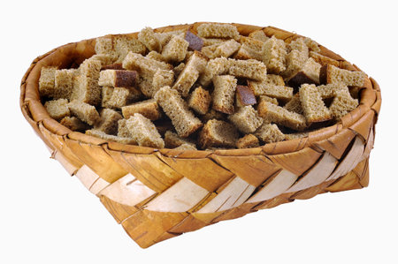 Home-made brown rusks in big birch-bark box over white backgroundの写真素材