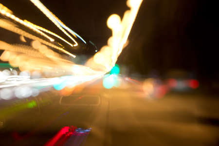 Defocused and motion blurred night scene with traffic lightsの写真素材