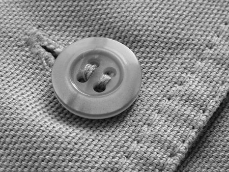 a close-up black and white fragment of the denim trousers with a buttonの写真素材