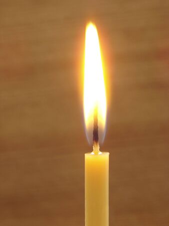 close-up of the burning candle at brown backgroundの写真素材