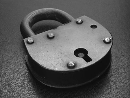 old black padlock at the black leather background                               の写真素材
