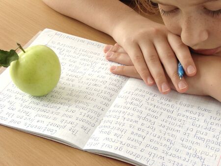 resting schoolgirl with notebook and apple                               の写真素材
