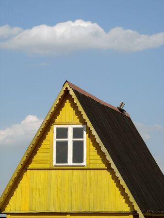 wooden cottage fragment against blue sky with clouds                               の写真素材