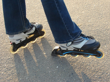 kid legs with roller skates at playground                               