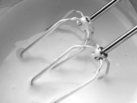 electric mixer blades in the bowl with creme                                