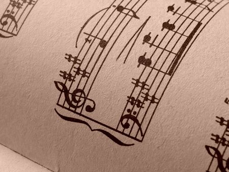 sepia toned open old sheets of musical notes fragment                               の写真素材