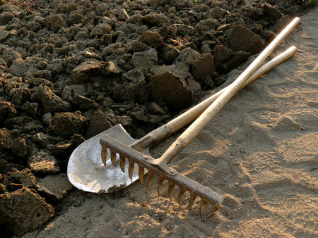 rake and spade at the edge of ploughed ground