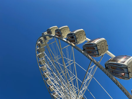 Ferris wheel on blue sky background in the amusement park, close-up