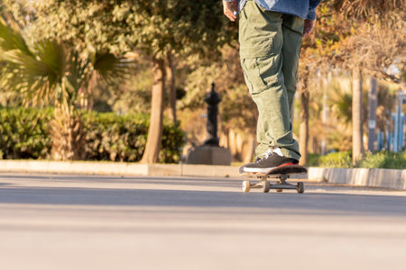 Adult man in the city walking with his short flat skateboardの写真素材