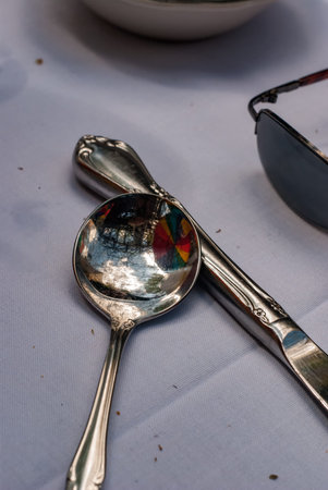 Silverware on white table cloth, with reflections