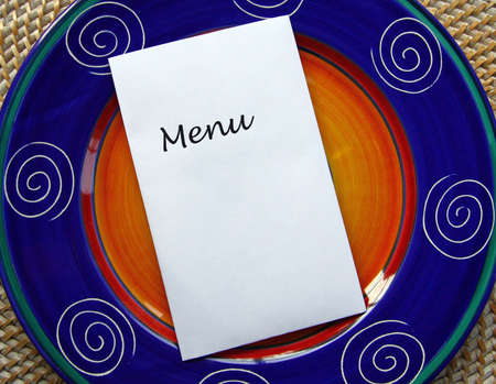 White paper with word MENU and copy space on top of blue Mexican style plate.の写真素材
