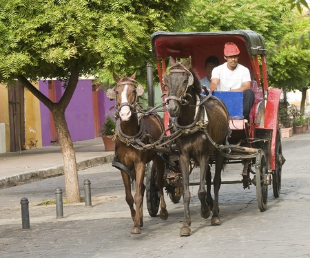 GRANADA, NICARAGUA - SEPT 16: Horses transporting people by the main street on September 16, in Granada, Nicaragua. Horse carriages are a common way to get around this small Nicaraguan town.のeditorial素材
