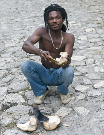 MILOT, HAITI - NOV 18, Coconut street vendor at work  on the road to the Citadelle fortress on November 18, 2013 in Milot, Haitiのeditorial素材