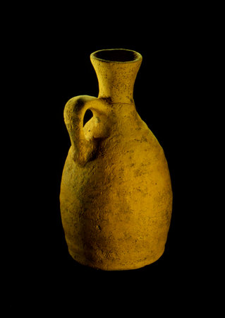Old clay vase on a black background. Isolated object.の写真素材