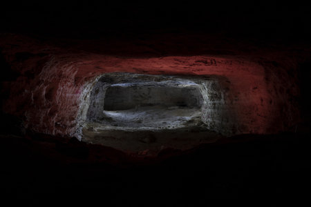 Interior view of a cave, illuminated by red and orange lightsの写真素材