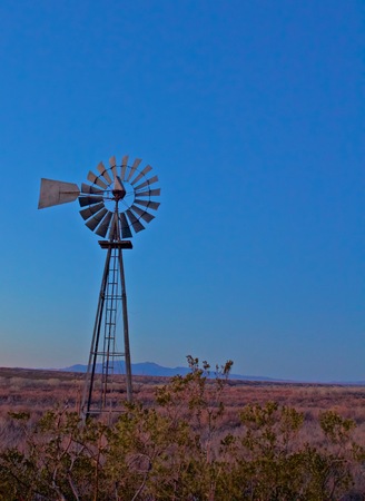 Old Lone Windmill Sits Still at Dusk with Mountain in the Distant Backgroundの写真素材
