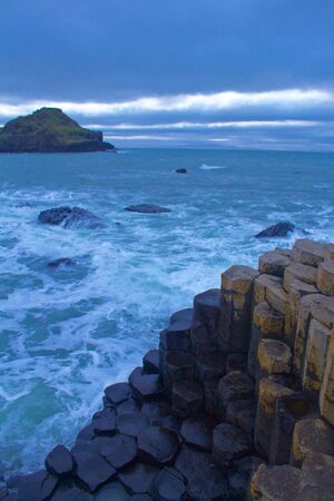 View of the Rocks of Giants Causeway with sea sprayed rocks and Ocean behindの写真素材