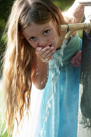 Little quenches thirst at the fountainの写真素材
