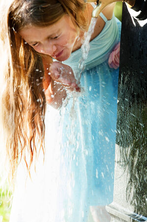 Little quenches thirst at the fountainの写真素材