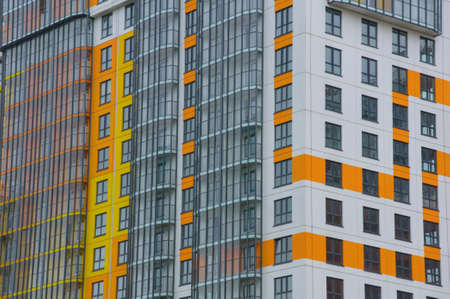 facade of a multi-storey building with white balconies and orange linesの写真素材