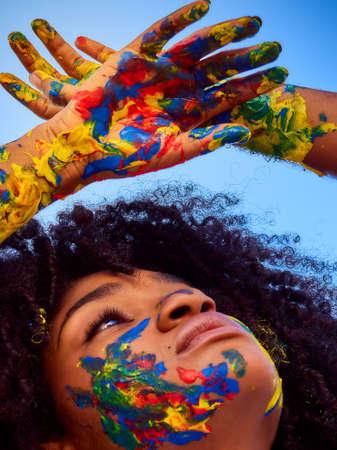 Little girl enjoying nature with her face painted in different colorsの写真素材