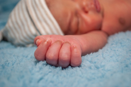 Newborn baby sleeping on blue blanket. Shallow depth of field.の写真素材