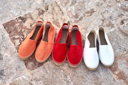 Pair of red and white slippers on the stone floor.の写真素材