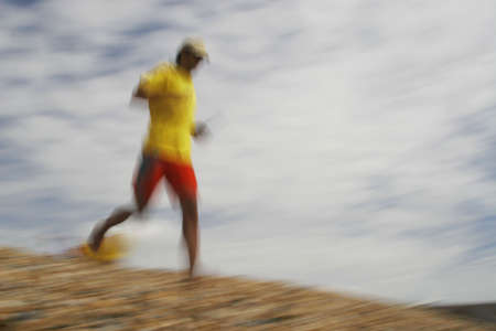 A motion blurred shot of a lifeguard running down the beachの写真素材